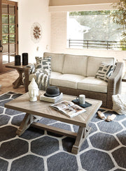 Outdoor Ashley Furniture Beachcroft outdoor conversation set with cushioned seats and a central table, perfect for patio lounging.