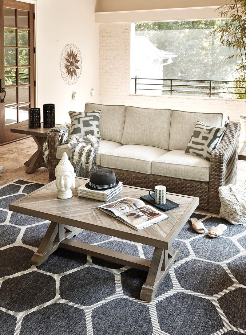 Outdoor Ashley Furniture Beachcroft outdoor conversation set with cushioned seats and a central table, perfect for patio lounging.