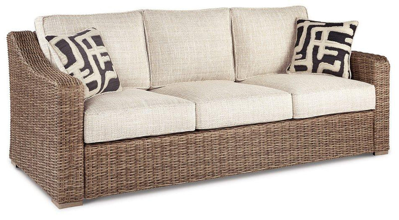 Ashley Furniture Beachcroft outdoor sofa with plush cushion, weather-resistant wicker design, perfect for outdoor lounging and relaxation.