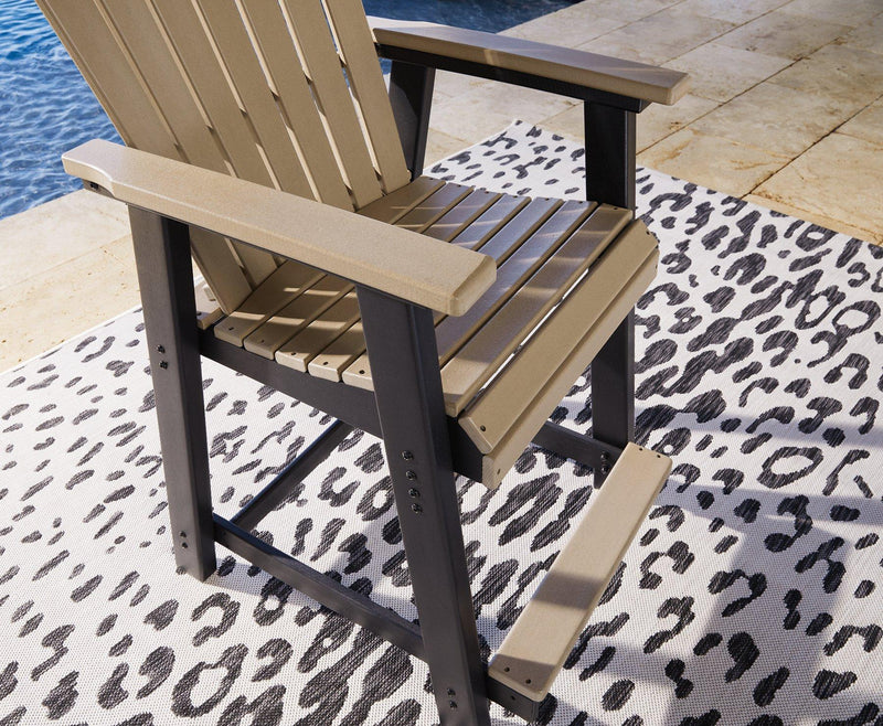 Outdoor dining set by Ashley Furniture with a rectangular table and six chairs, set on a patio with greenery in the background.