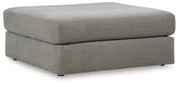 Oversized Ashley Furniture Avaliyah Ottoman with plush fabric and tufted top, used as a versatile accent piece in living room decor