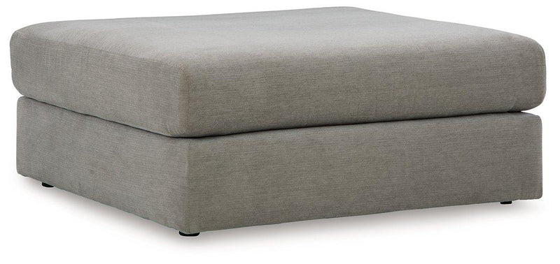 Oversized Ashley Furniture Avaliyah Ottoman with plush fabric and tufted top, used as a versatile accent piece in living room decor