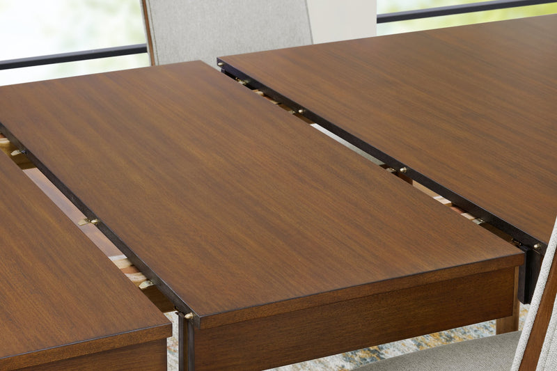 Close-up of Ashley Furniture Lyncott dining room set with detailed leaf pattern on wooden table surface.